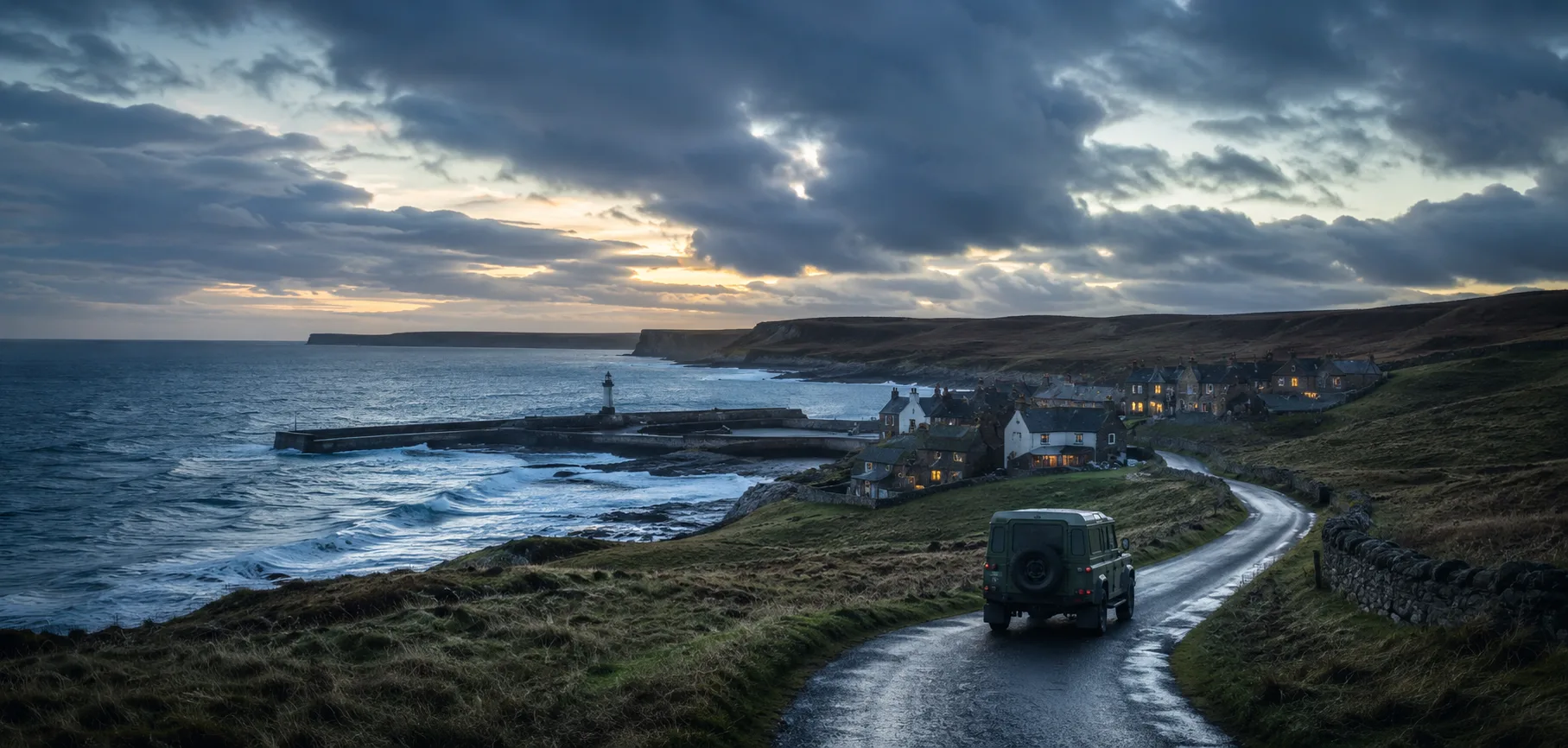 A windswept coastal fishing village at dusk with a Land Rover on the road, evoking the setting of Vera